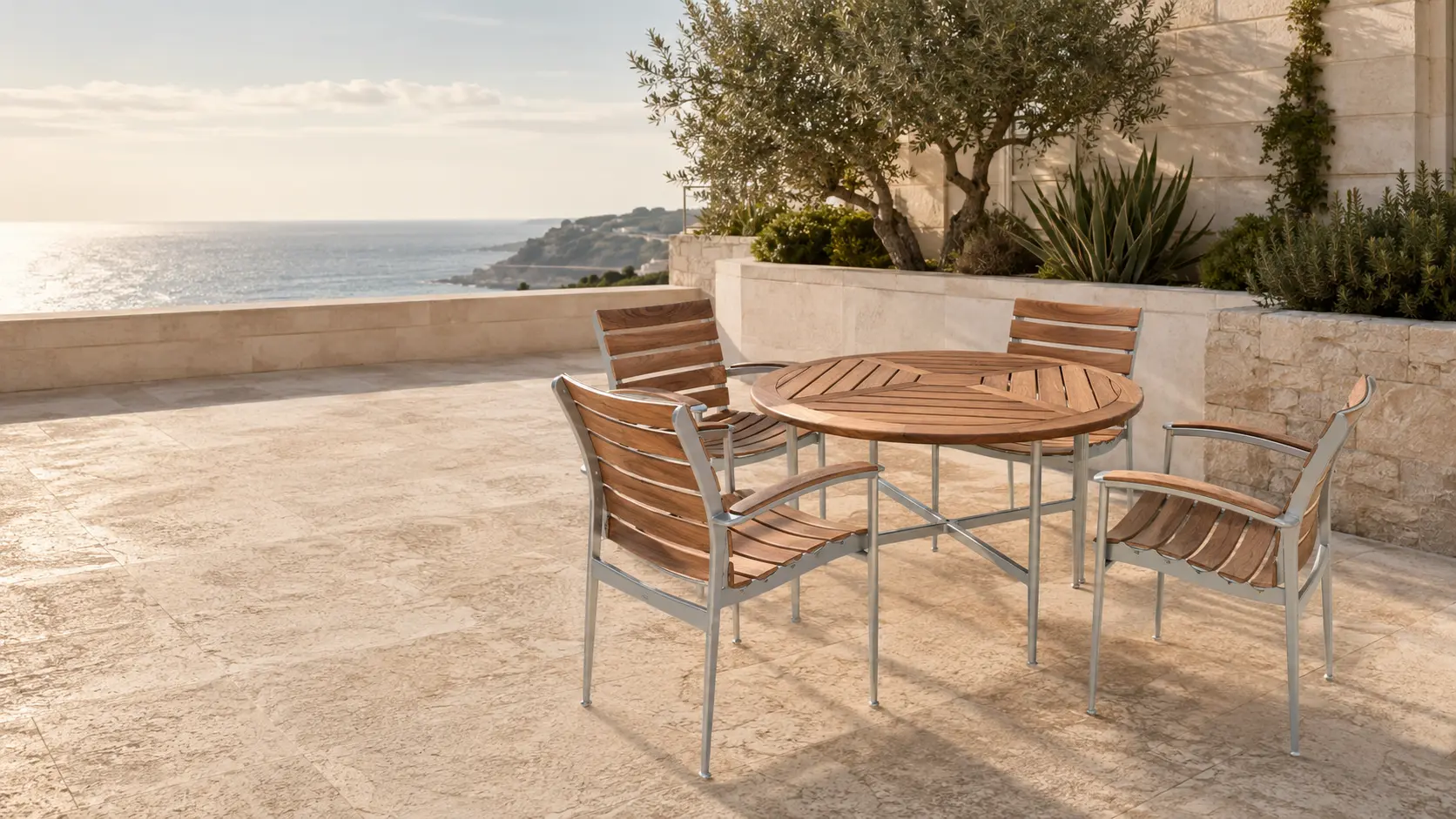 Strata natural teak dining chairs and round dining table on an upscale Mediterranean coastal terrace